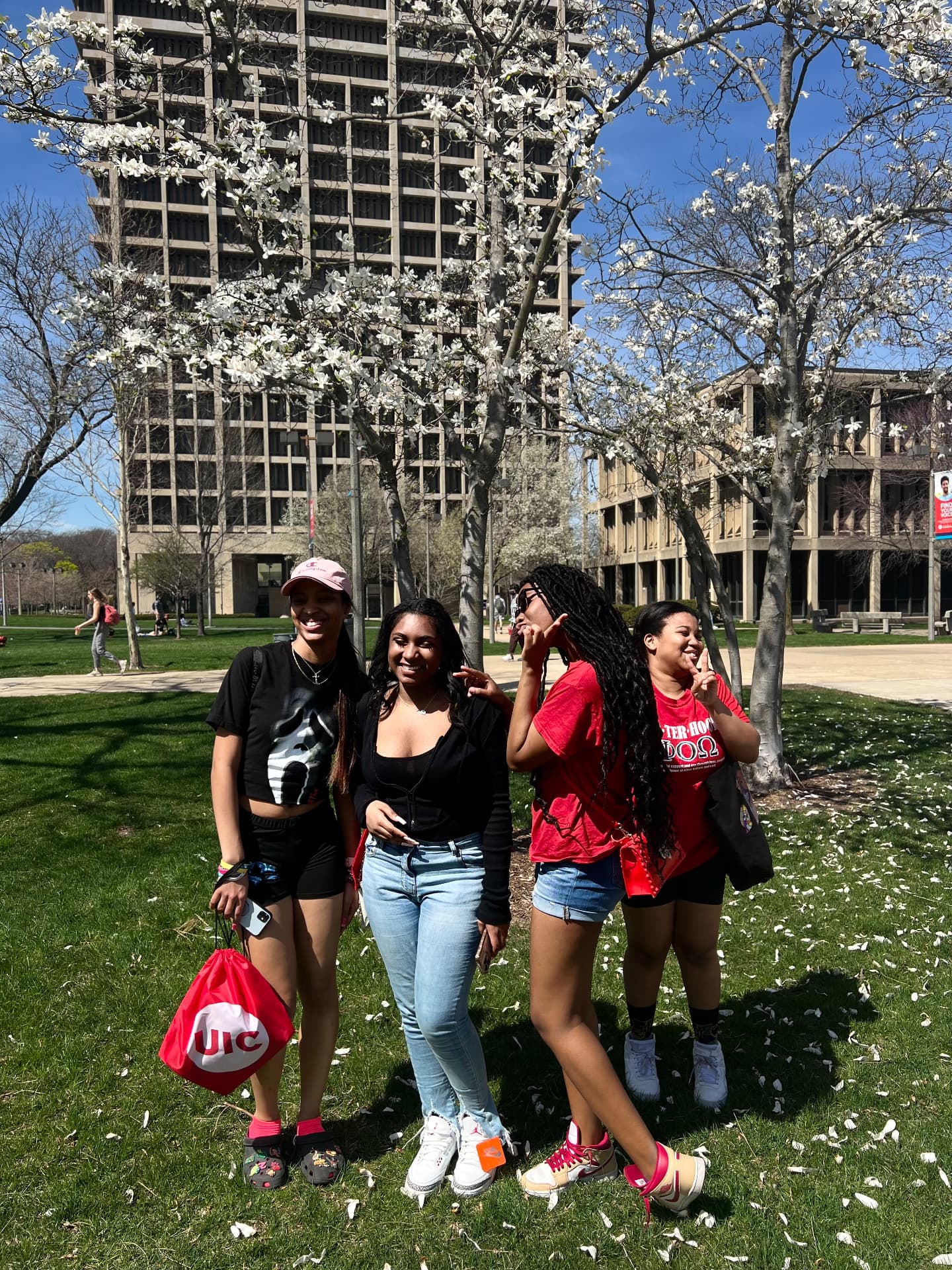 Members smiling on the UIC campus under blooming trees